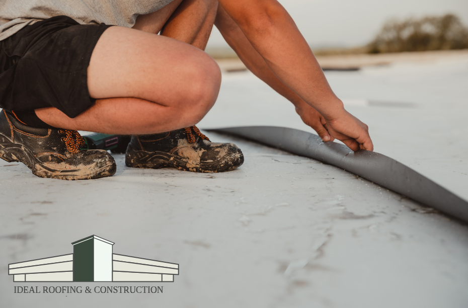 Contractor applying roof coating material to a commercial TPO roof