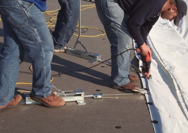 Men working on roof, completing commercial roof replacement