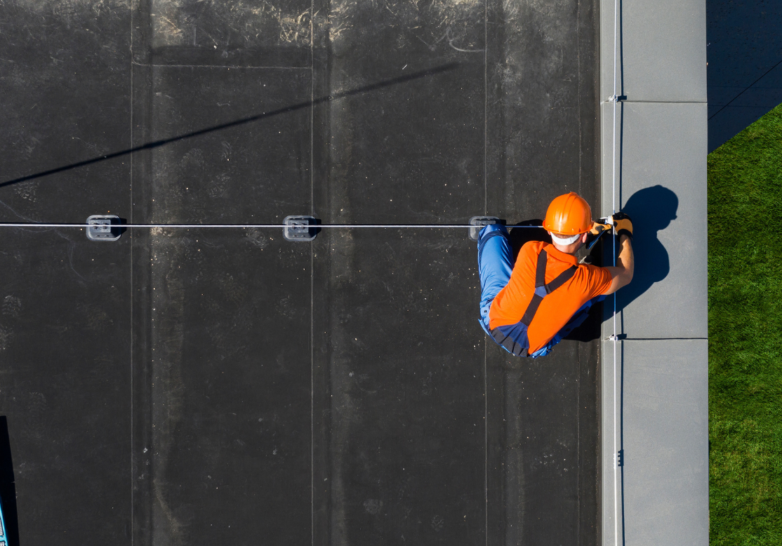 Commercial roof repair, roofer in high-vis on flat commercial roof